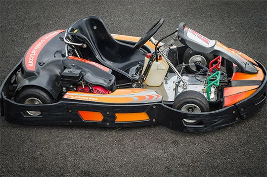 Photo d'un Kart Technikart Sodi fun kid 120cc. Fond orange et rayures blanches.